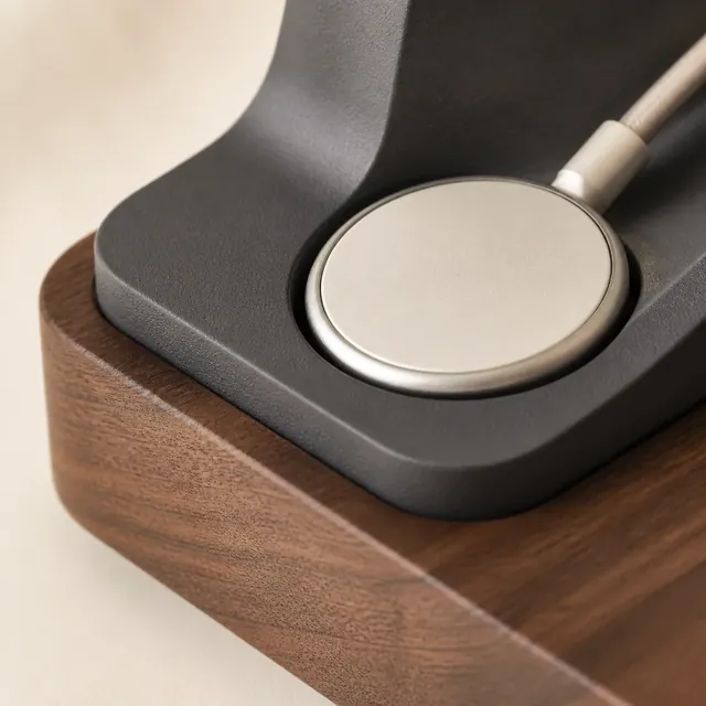 Concept render detail of a magnetic cable puck seated in walnut